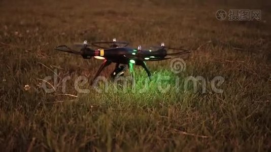 晚上，带着摄像机的无人机试图从草地上起飞视频