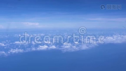 在地平线上明亮的蓝天上的蓬松的云彩。 蓝天白云从窗外的飞机上眺望视频