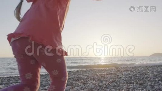 小女孩跑到海滩上迎接太阳，高兴地跳起来视频