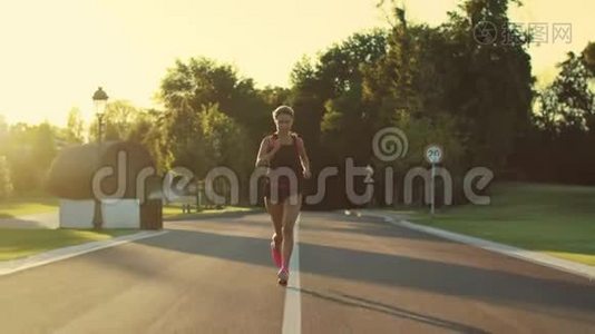 日落时分在公园里跑步的运动女子。 女子跑步训练户外运动视频