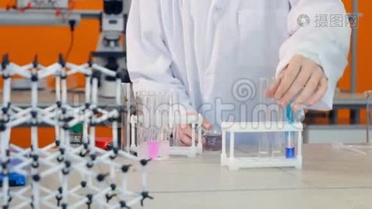 中学生在实验室做化学测试。 手将化学试剂加入小瓶，试管中..视频