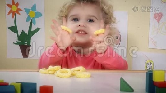 饥肠辘辘的孩子坐在他房间的桌子旁吃玉米脆片视频