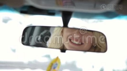 一个漂亮女孩在汽车镜子里的倒影。视频