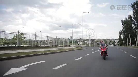一个男人和一个女孩骑着一辆红色自行车沿着这条路骑视频
