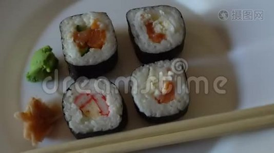 日本寿司卷各种，在白色盘子上旋转。视频