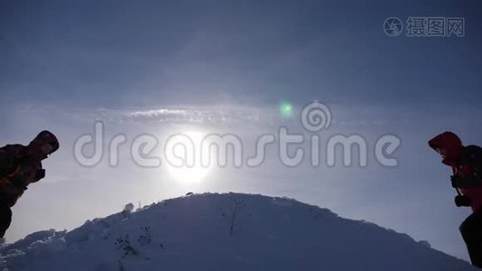 游客们来到雪山顶上，在黄色日落的背景下为胜利而欢欣鼓舞。 游客的团队合作和视频