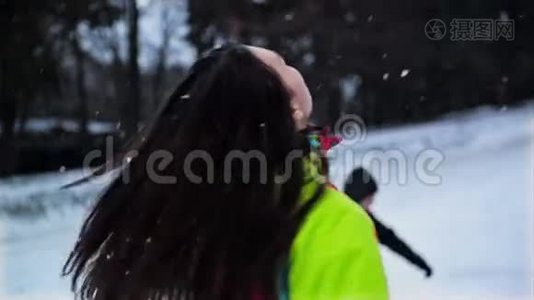 快乐的女人正试图抓住一个雪花享受冬天的户外活动。 色彩鲜艳的滑雪服和长裙的滑稽女孩视频