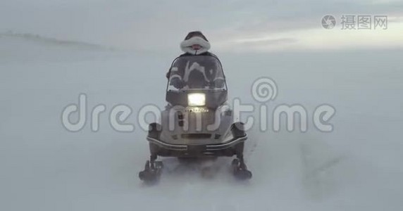 一个穿着驯鹿大衣，带着毛皮帽的冒险者在暴风雪中看着一辆雪车。 2016年北极探险。 4k视频