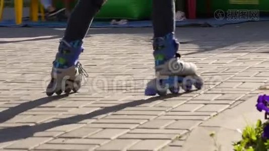 穿滑轮鞋的小孩的腿。 儿童卷在帕布里克公园。 慢动作视频