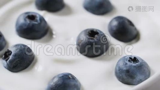 特写蓝莓在天然酸奶旋转。 4k. 水果背景。视频