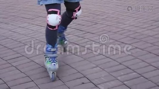 穿滑轮鞋的小孩的腿。 儿童卷在帕布里克公园。 慢动作视频