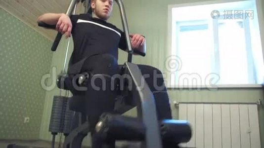 年轻人在家里健身器材上锻炼腿部肌肉视频