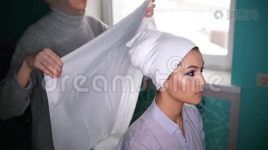 两名穆斯林妇女系上伊斯兰头巾，准备举行婚礼视频