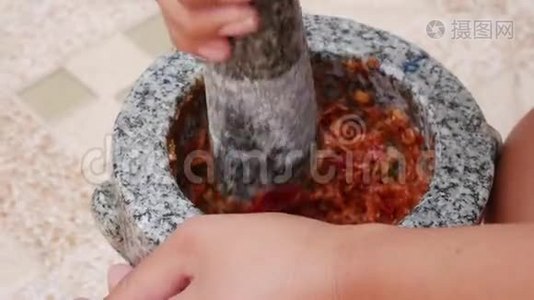 泰国辣椒和大蒜用杵在石臼里敲打。 准备泰国汤酱的女人汤姆山药。 关上门。 4k视频