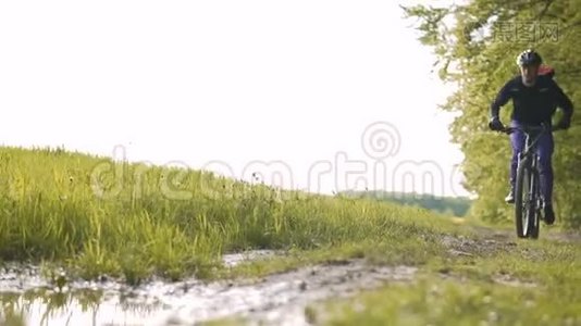 背包客在森林水坑里骑自行车视频