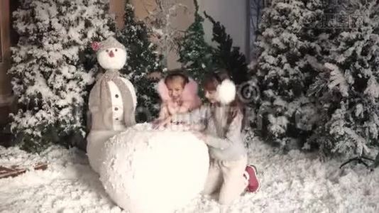 圣诞节或新年。 孩子们堆雪人。 两个小女孩做一团雪视频
