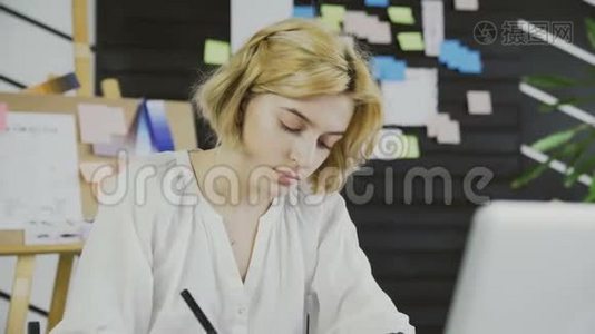 年轻女性在办公室工作，带着平板电脑视频