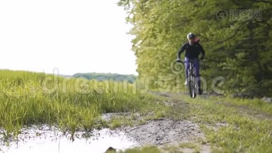 背包客在森林水坑里骑自行车视频