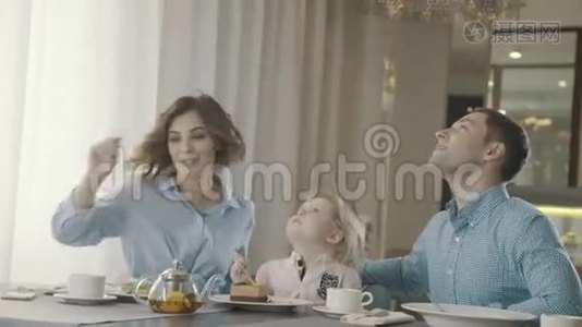 现代家庭带着一个小孩在家庭餐厅吃甜点视频