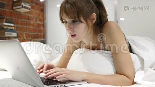 卧床不起的妇女在笔记本电脑上工作，并应对损失视频