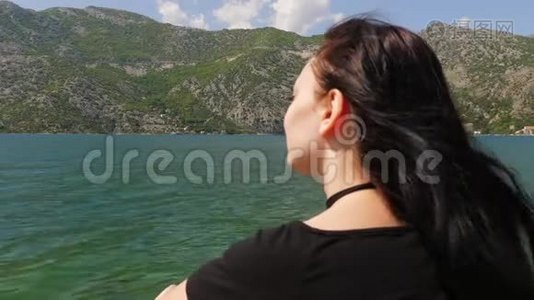 一个年轻的女人看着水和山视频
