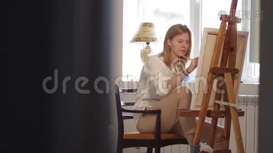 坐在椅子上画画的女人视频
