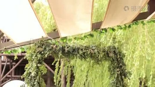 咖啡馆里绿色树枝的婚礼拱门。视频