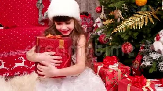 孩子喜欢圣诞节的礼物，小女孩在圣诞前夜在家里玩礼物，孩子狂欢节服装视频