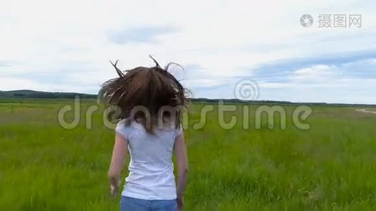 美丽的黑发女孩跑过田野慢镜头拍摄视频