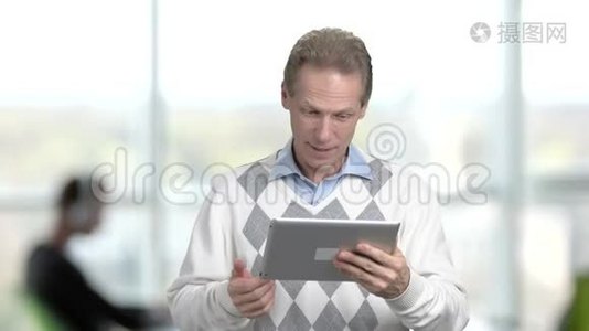 成熟的经理通过个人电脑平板电脑交谈。视频