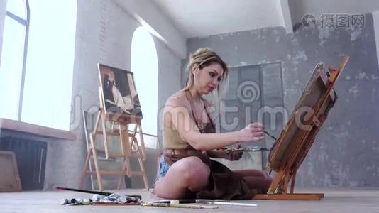 女艺术家坐在地板上画画画室里的画视频