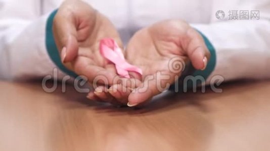 一位女医生举着粉红色的丝带，为乳腺癌的认识服务视频