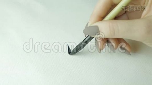 女人`手写着中文象形文字。 女手握着毛笔书法汉字，合上视频