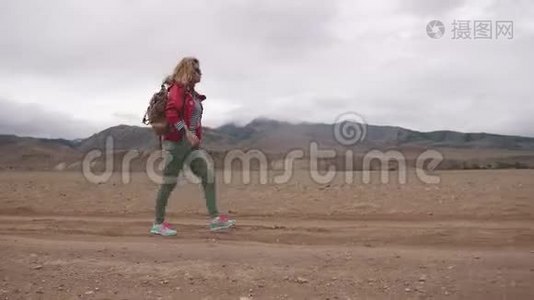 带背包的游客在山上的肖像。 女孩旅行者在恶劣的天气里行走在山区视频