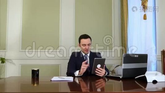 商人在平板电脑上聊天，在办公室做文书工作视频