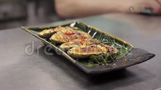 在餐厅或咖啡厅为客户提供特殊的绿色盘子中的日本菜。视频