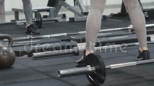 苗条的女孩在现代健身房锻炼`伸展腿部和肌肉视频