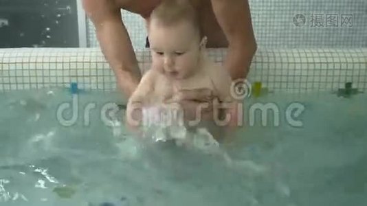 可爱的孩子把水溅在孩子的水池里视频