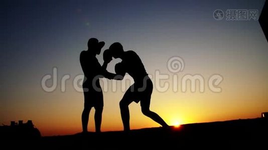 两个黑暗的男性人物，日出时，逆光，拳击，拳击，拳击，拳击，训练一对技巧视频