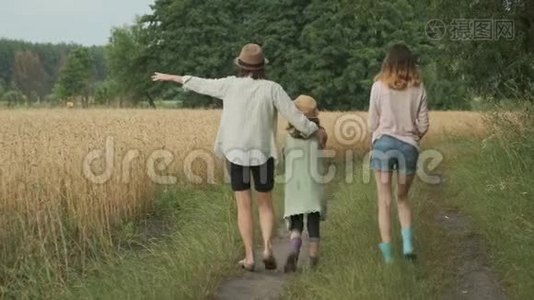 家庭母亲和孩子两个女儿一起走在乡间小路上，后景视频