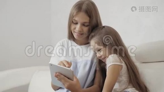 两个姐姐看着平板电脑，坐在沙发上玩游戏，小婴儿和成年妹妹视频
