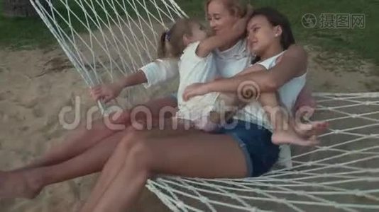 小女孩在吊床上轻轻拥抱着妈妈和妹妹视频