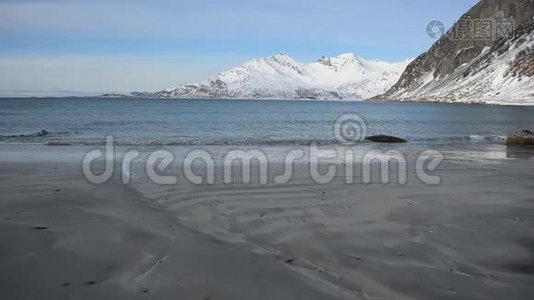 清冽的寒潮冲击着深秋浅棕色的沙质海岸，带着雄伟的雪山背景视频