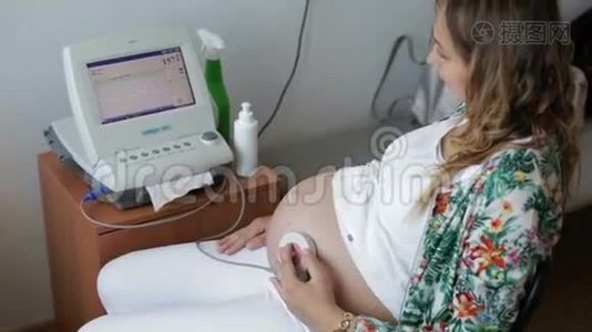 妇女在胎儿心脏监测期间检查。视频