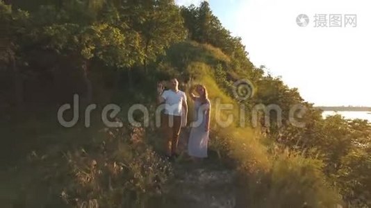 一对幸福的夫妇站在山上挥舞着他的手臂视频