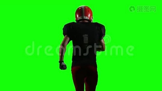 运动员摸着手中的球，然后跑。 绿色屏幕，背面视图，视频