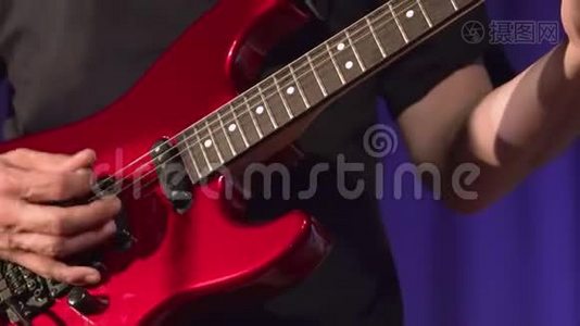 音乐家在舞台上演奏红色电吉他。视频
