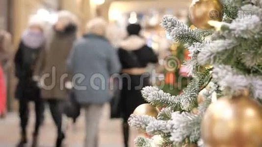 商场里喜庆的气氛。 在前景的圣诞杉。 不在焦点的人走路和买礼物。视频