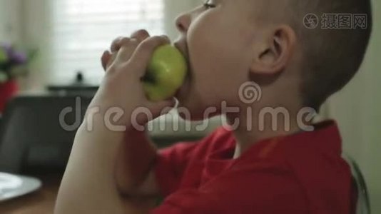 那个大眼睛的小男孩在咬苹果。视频