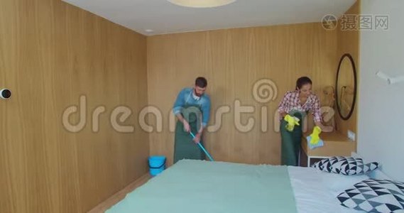 专业清洁工在酒店房间或公寓房间内统一清洗地板和擦拭家具上的灰尘视频